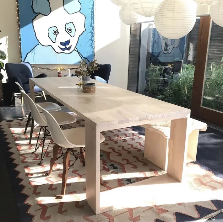 Custom hardwood dining table with a solid timber top and rectangular end frames
